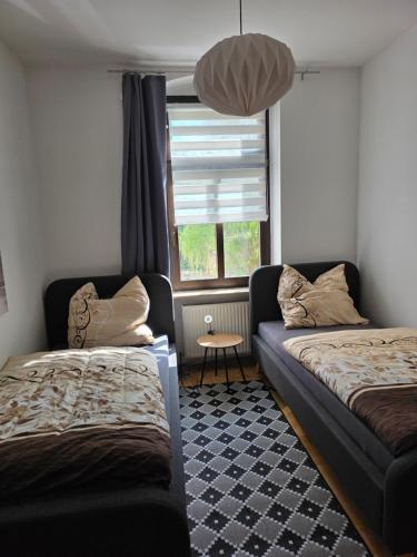 a bedroom with two beds and a window at FEWO Civrilli 1 Zeitz in Zeitz