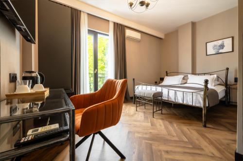 a bedroom with a bed and a desk and a chair at Golden Boutique Hotel in Tbilisi City