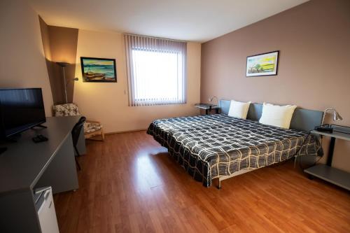a bedroom with a bed and a flat screen tv at ATM Hotel in Sofia