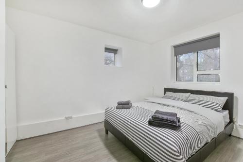 um quarto branco com uma cama com um saco em Sachin's 2 Bedrooms Apartment em Londres