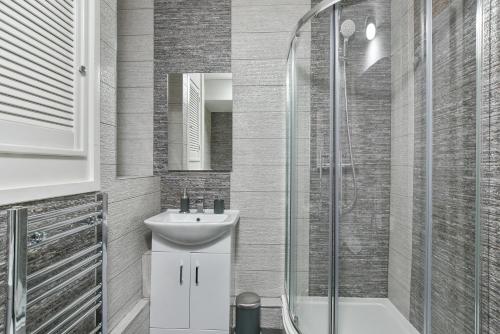 uma casa de banho com um lavatório e um chuveiro em Sachin's 2 Bedrooms Apartment em Londres