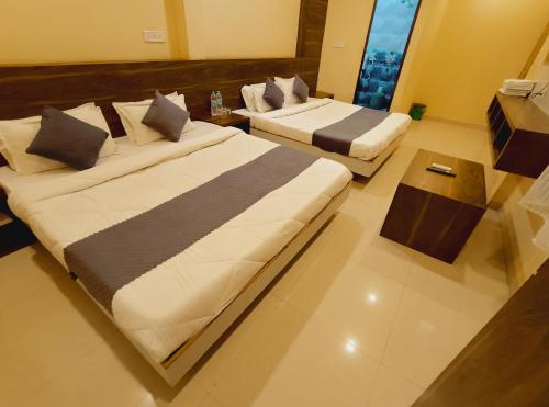 a hotel room with two beds and a table at shree krishna Hotel in Ujjain