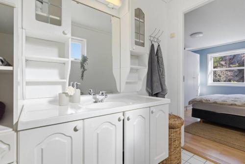 a white bathroom with a sink and a mirror at Waterfront Home-Tonsberg in Tønsberg