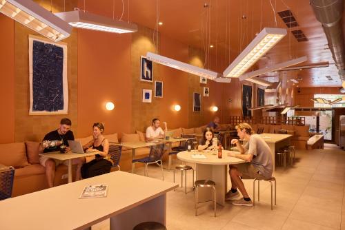 a group of people sitting at tables in a restaurant at Latroupe Poblenou Beach in Barcelona