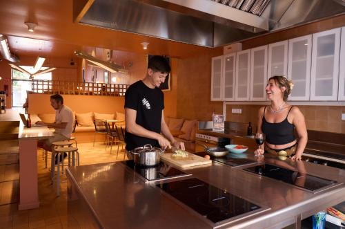 a man and woman standing in a kitchen preparing food at Latroupe Poblenou Beach in Barcelona
