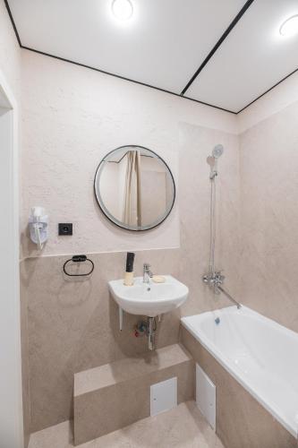 a bathroom with a sink and a mirror at UIDE Apart hotel in Almaty