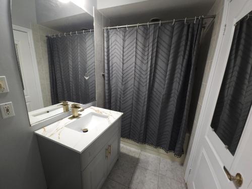 a bathroom with a sink and a shower curtain at Lakefront Suite with Geodesic Dome Experience in Stouffville