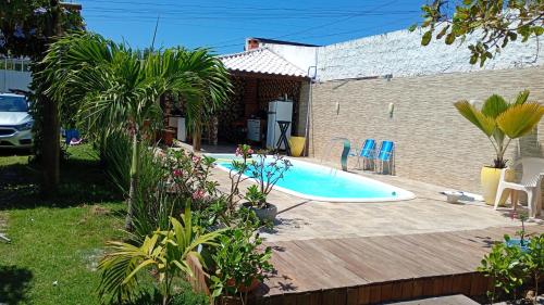 ein Swimmingpool in einem Garten mit Holzterrasse in der Unterkunft Arborizado in Camaçari