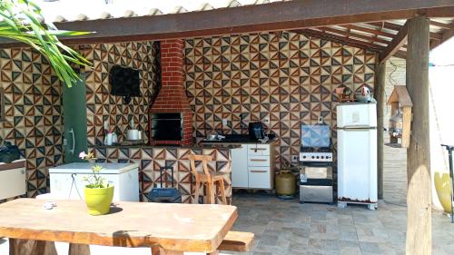 eine Küche mit einem Holztisch und einem Kühlschrank in der Unterkunft Arborizado in Camaçari