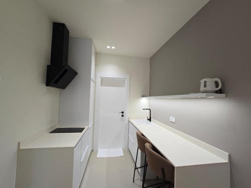 a kitchen with a white counter top and a sink at Suites By Jordan's Hotel in Vlorë