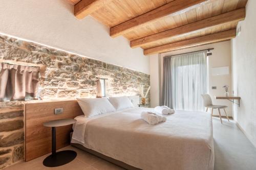 a bedroom with a large bed and a stone wall at Agriturismo Bramalpane in Bagno di Romagna