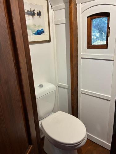 a small bathroom with a toilet and a window at Idyllic Roulotte in Les Assions