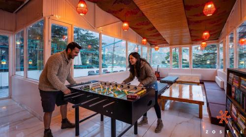 a man and woman playing a game of foosball at Zostel McLeodganj in McLeod Ganj