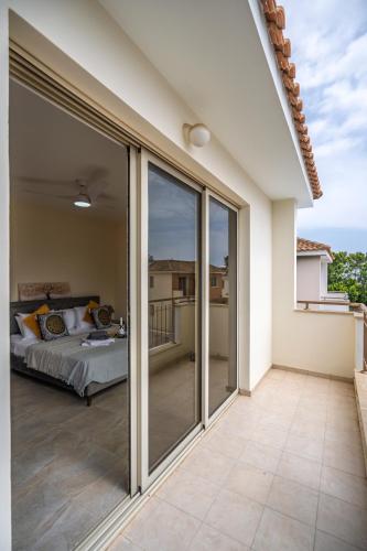 a bedroom with sliding glass doors leading to a bed at Mambo Private Villa with Pool by the Beach in Paralimni