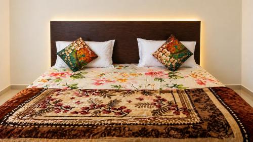 ein Bett mit einer Decke und Kissen darauf in der Unterkunft Hotel The Height in Chandīgarh