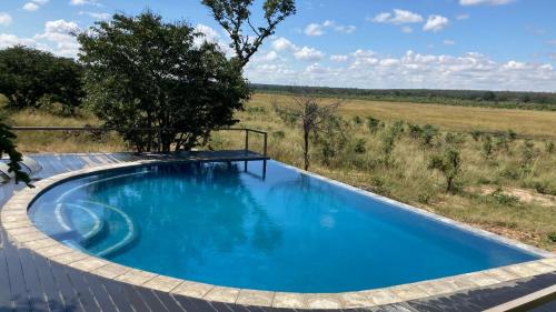 a swimming pool with a fence around it at Chamabondo Luxury Tented Camp in Victoria Falls