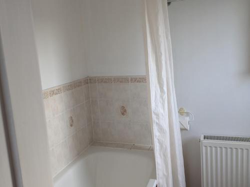 a bathroom with a bath tub with a shower curtain at Rousay&nbspCottage in Orkney