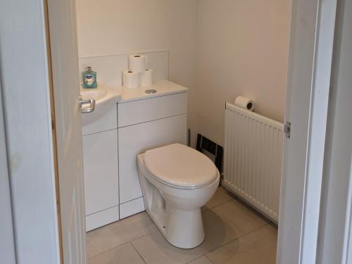 a white bathroom with a toilet and towels on it at Lower Cottage in Orkney