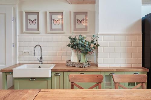 a kitchen with a sink and a vase of flowers on a counter at Królowa Kaczek - własna plaża, pomost, sauna z widokiem na wodę i sala warsztatowa in Sorkwity