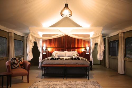 a bedroom with a canopy bed in a tent at Chamabondo Luxury Tented Camp in Victoria Falls