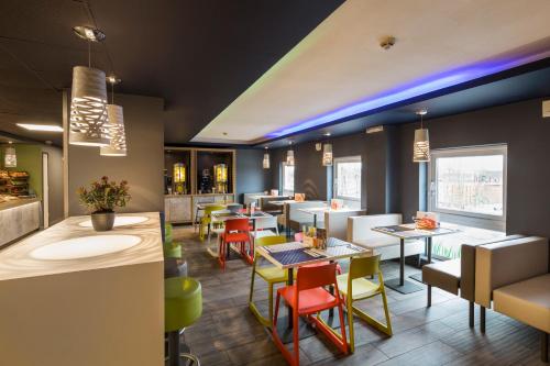 a restaurant with tables and chairs and a bar at ibis budget Glasgow in Glasgow