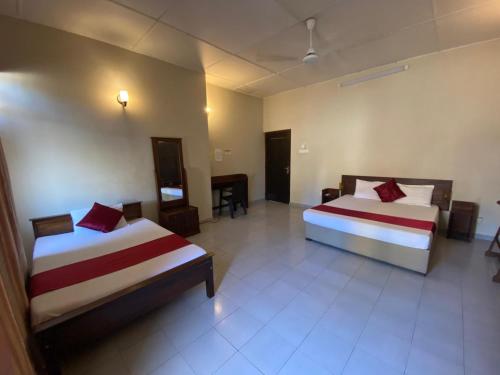 a hotel room with two beds and a television at MercuryFM 103 Guest House - Colombo 3 in Colombo
