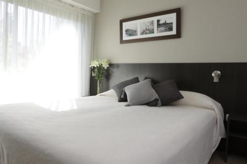 a white bed in a bedroom with a window at Rosario Temporal in Rosario