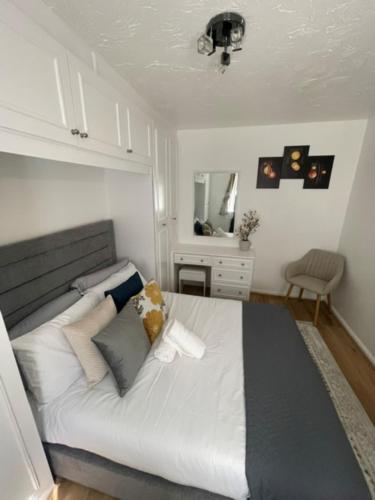 a bedroom with a large white bed with pillows at The Wigmore house in Luton