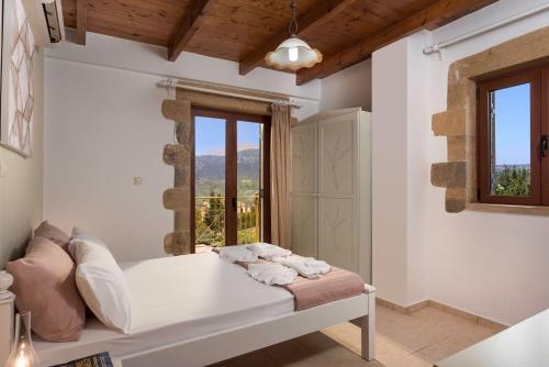 a white room with a bed and a window at Villa Gianna by PosarelliVillas in Fílippos