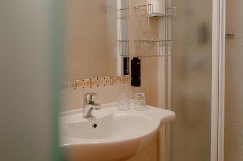a white sink in a bathroom with a shower at Das Bergfrieden Nature Active Hotel in Martello