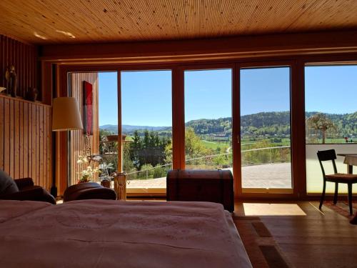 a bedroom with a large window with a view at Längseeleit'n in Sankt Georgen am Längsee