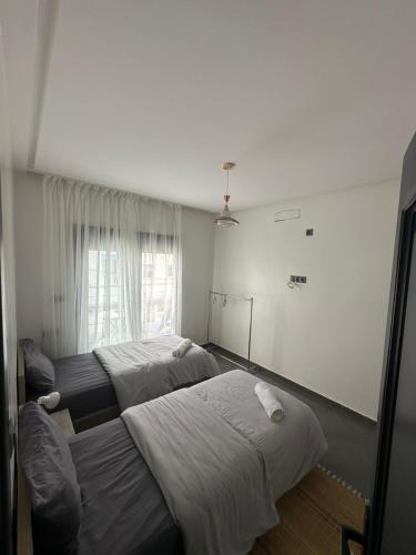 a bedroom with two beds and a window at Wavera Surf Camp in Imsouane