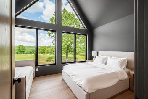 a bedroom with a white bed and large windows at Highpoint in New Plymouth
