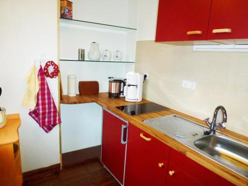 a kitchen with red cabinets and a sink at Villa-Hufeland in Berlin