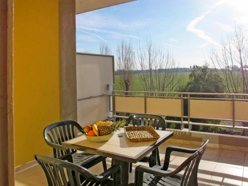a table with chairs and a bowl of fruit on a balcony at Residenza Pierre & Vacances Luni Mare in Luni