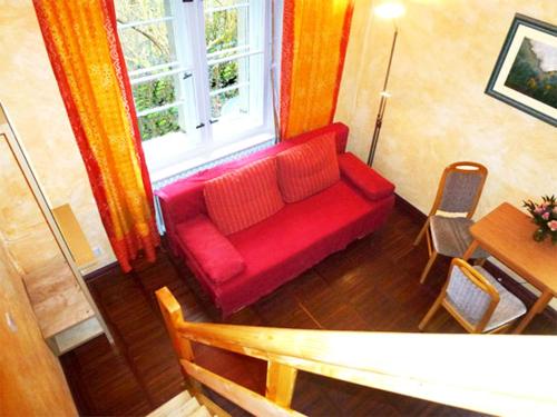a red couch in a living room with a window at Villa-Hufeland in Berlin