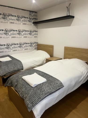 two beds in a room with a wall with writing at Torres Vedras House in Silveira