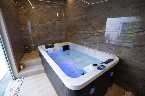 a bathroom with a large tub with a shower at Torres Vedras House in Silveira