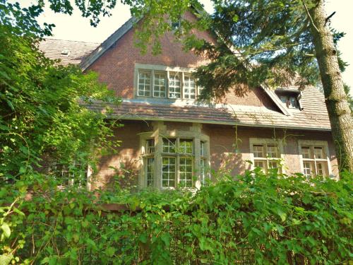 a red brick house with white windows and trees at Villa-Hufeland in Berlin