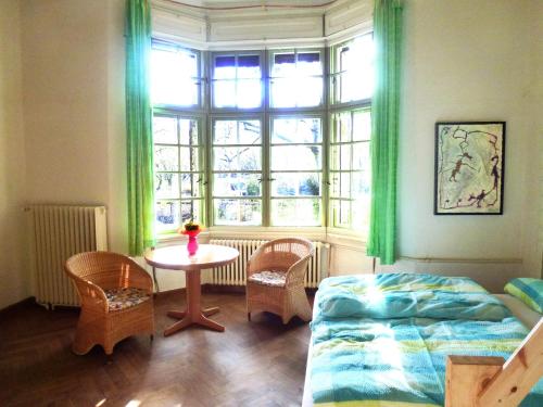 a bedroom with a bed and a table and a window at Villa-Hufeland in Berlin