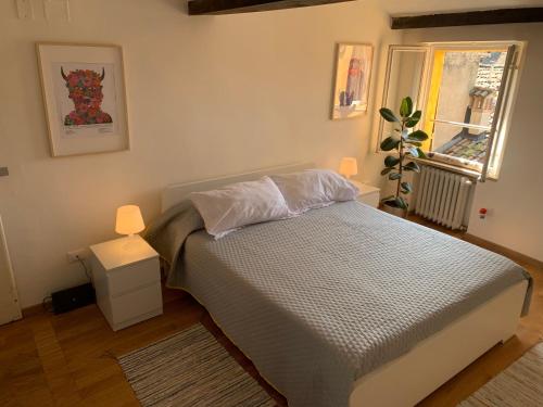 a bedroom with a bed with two lamps and a window at Domus Pioppa in Modena