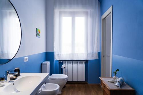 a blue bathroom with a sink and a toilet at Lucignolo in Fucecchio