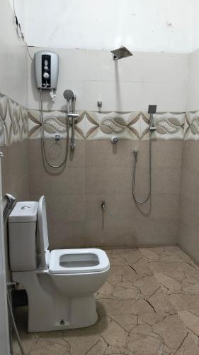a bathroom with a toilet and a shower stall at Calm Night Surf Stay in Arugam Bay