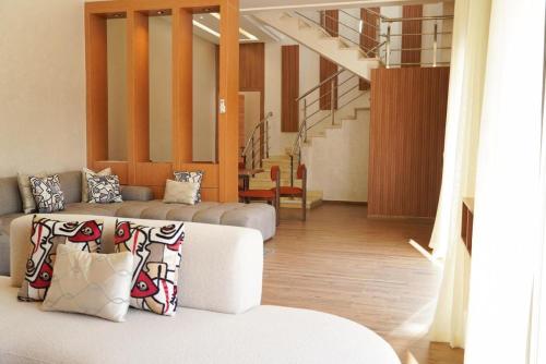 a living room with two couches and a staircase at villa Tarik with private pool in El Aïn