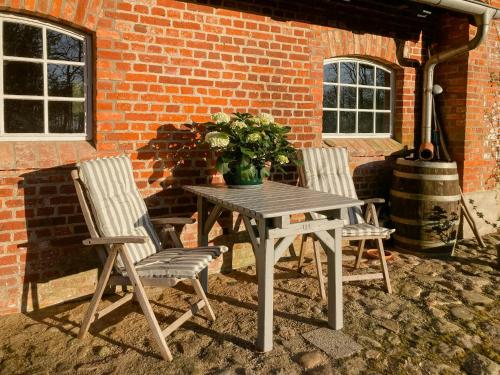a wooden table with two chairs and a vase of flowers at Apartment In A Converted 1875 Creamery in Travenhorst