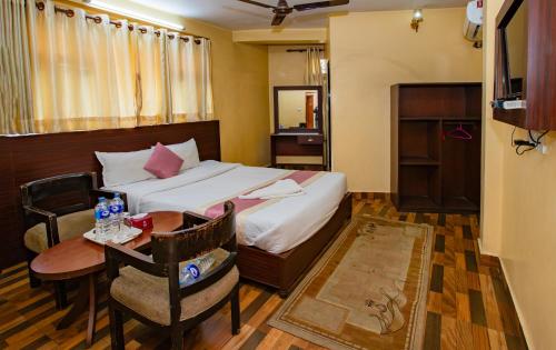 a hotel room with a bed and a table and a desk at Rameshworam Hotel in Kathmandu