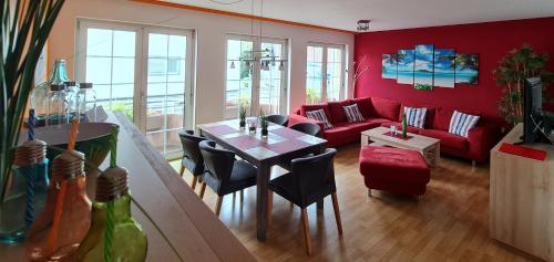 a living room with a red couch and a table at Ferienwohnung Nickmann im Scheffelhof in Bad Säckingen