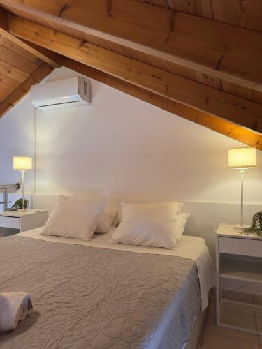 a bedroom with a bed with white sheets and wooden ceilings at Tousso Apartment Loggos in Longós