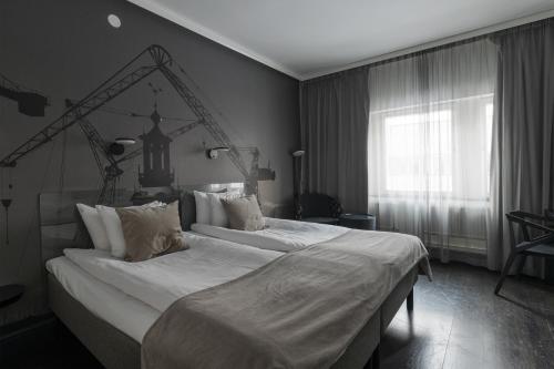 a large bed in a bedroom with a window at Hotel C Stockholm in Stockholm