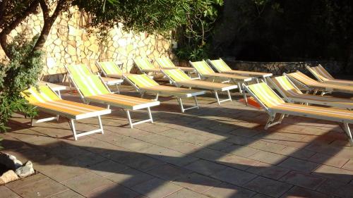 a row of lounge chairs sitting on a patio at Hotel Club Torre Capovento in Sperlonga